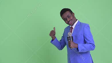 Happy young African businessman as newscaster presenting something