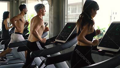 Row of people exercising on treadmills at modern gym. Fitness men and women working out together