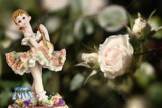 Vintage Girl Figurine wearing petticoat with Guitar and a white rose on creamy green background. Composition