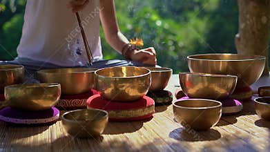 Superslowmotion shot of a woman master of Asian sacred medicine performs Tibetan bowls healing ritual. Meditation with