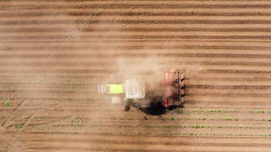 Agricultural machinery for processing of the soil in the field. The tractor plows the soil, and a top view.