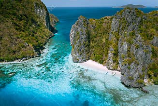 El Nido, Palawan, Philippines. Aerial view of tropical sea stack Island with tourist boats moored at white sandy beach