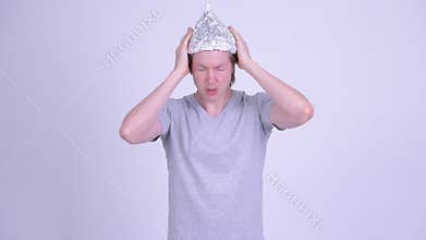 Young man wearing tin foil hat as conspiracy theory concept