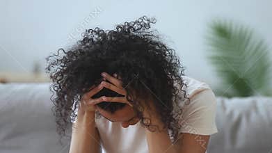 African woman holding head with hands crying feels despair