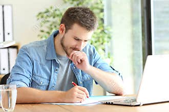 Pensive entrepreneur handwriting at office