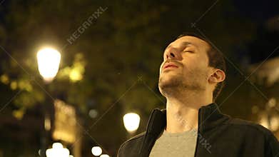 Man breathing fresh air in the night in the street