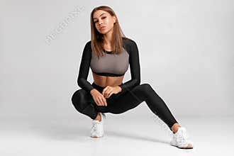 Sexy fitness woman. Beautiful athletic girl on the gray background