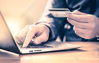 Man making an online payment with credit card and laptop. Digital e commerce service. Happy customer shopping and paying.
