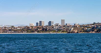Corona Del Mar beach with Newport Beach city skyline and mountains in the background