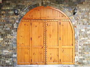 Medieval looking arched top doors set in a stone castle wall