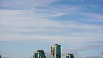 Timelapse calm evening sparse white clouds in sky over city