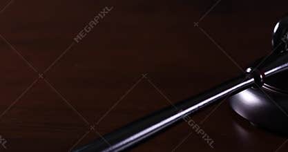 Slow Panning of Dark Wood Gavel on Dark Wood Surface