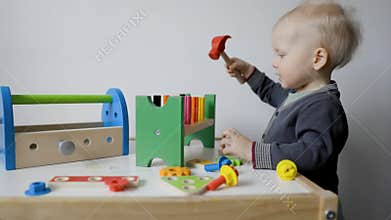 Toddler boy playing with toy tool box