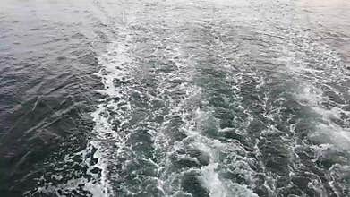 Ocean water wake flowing behind ship