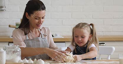 Happy family of two in aprons enjoying baking process together.