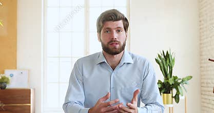 Millennial businessman talking to camera making conference video call