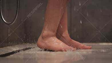 Woman `s legs close-up. Girl washing with gel in shower. Beauty care concept.