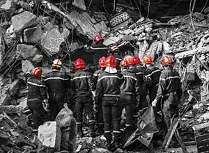 Firefighters, in red hats, are in catastrophe to save people