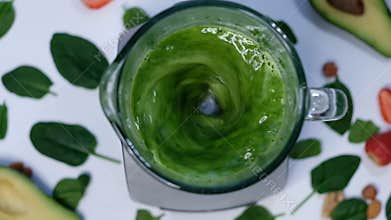 Healthy green smoothie blended with a blender. Spinach and avocado on a white background top view. Close up of cooking