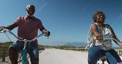 Front view old couple on bikes near the beach