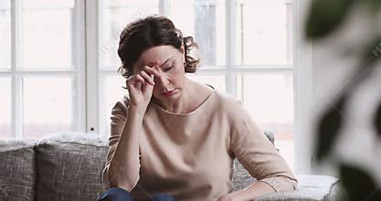 Sad middle aged 50s woman sit alone feel depressed