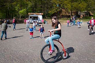 Child on a high wheel bicycle in the open air museum in Arnhem, the Netherlands