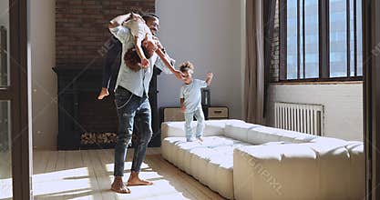Happy biracial man having fun with small adorable children.