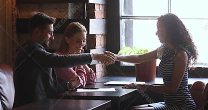 Satisfied smiling clients making agreement with mixed race professional.