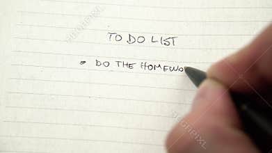 Human hand writing tasks on to do list, chore checklist in notebook