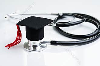 Graduation hat on doctor stethoscope, white background using as medical school, health care education or doctor`s university