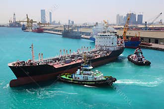 Boats docked to industrial ship in port sail