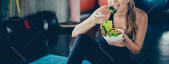 Beautiful young lady with salad in the Gym. Sport women exercise with healthy food.