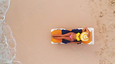Beach vacation in paradise tropical island, sexy suntan woman relaxing on beach and sea. Aerial top view.