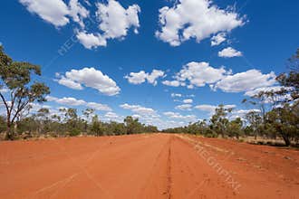 Wide gravel road under a blue sky