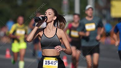 Athlete drink water bottle. Thirsty person run. Woman runner jog sport marathon.