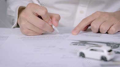 Buyers or sellers who are reading car lease or car insurance contract and signing. Sale agent deal to agreement car loan contract
