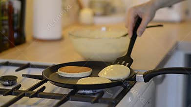 Closeup of cooking pancakes on a gas stove.