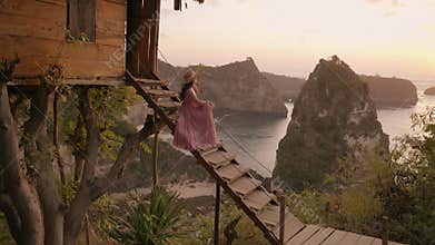 Nusa penida, Bali, indonesia, 4K video of woman pink dress sit of tree house