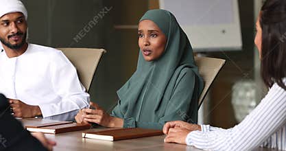 Sudanese businesslady in hijab lead meeting with businesspeople in office