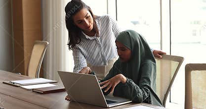 Two multinational women working on joint on-line project in office