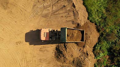 Drone footage of big truck moving dirt and dumping it
