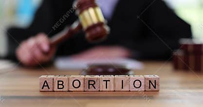 Word abortion and judge with gavel in courtroom