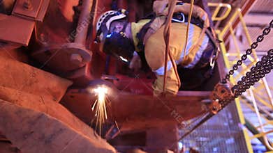 footage of rope access welder wearing safety equipment, glove protection working on twin rope 