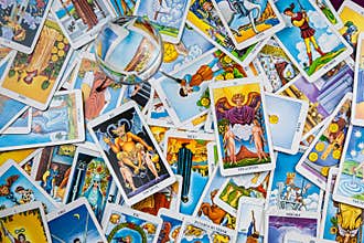 Mixed tarot cards on the table with a magic ball.