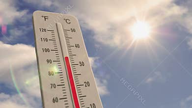 Thermometer on blue sky and shining sun