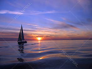 Yacht sailing at sunset