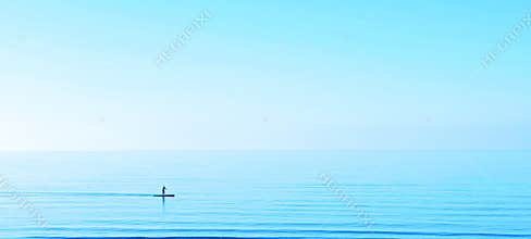 Summer Sup paddle boarder on board blue sea ocean water sky simple with copyspace
