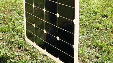 The flexible solar panel is rotated around the axis to show the thickness