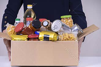 Woman volunteer hands holding food donation box with food grocery products. Donations for charity, food bank