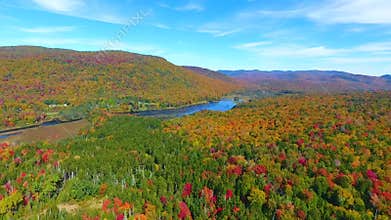 New York landscape aerial of colorful fall forests and mountains going towards small lake